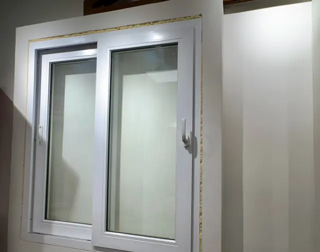 Finestra scorrevole in PVC bianco esposta in showroom